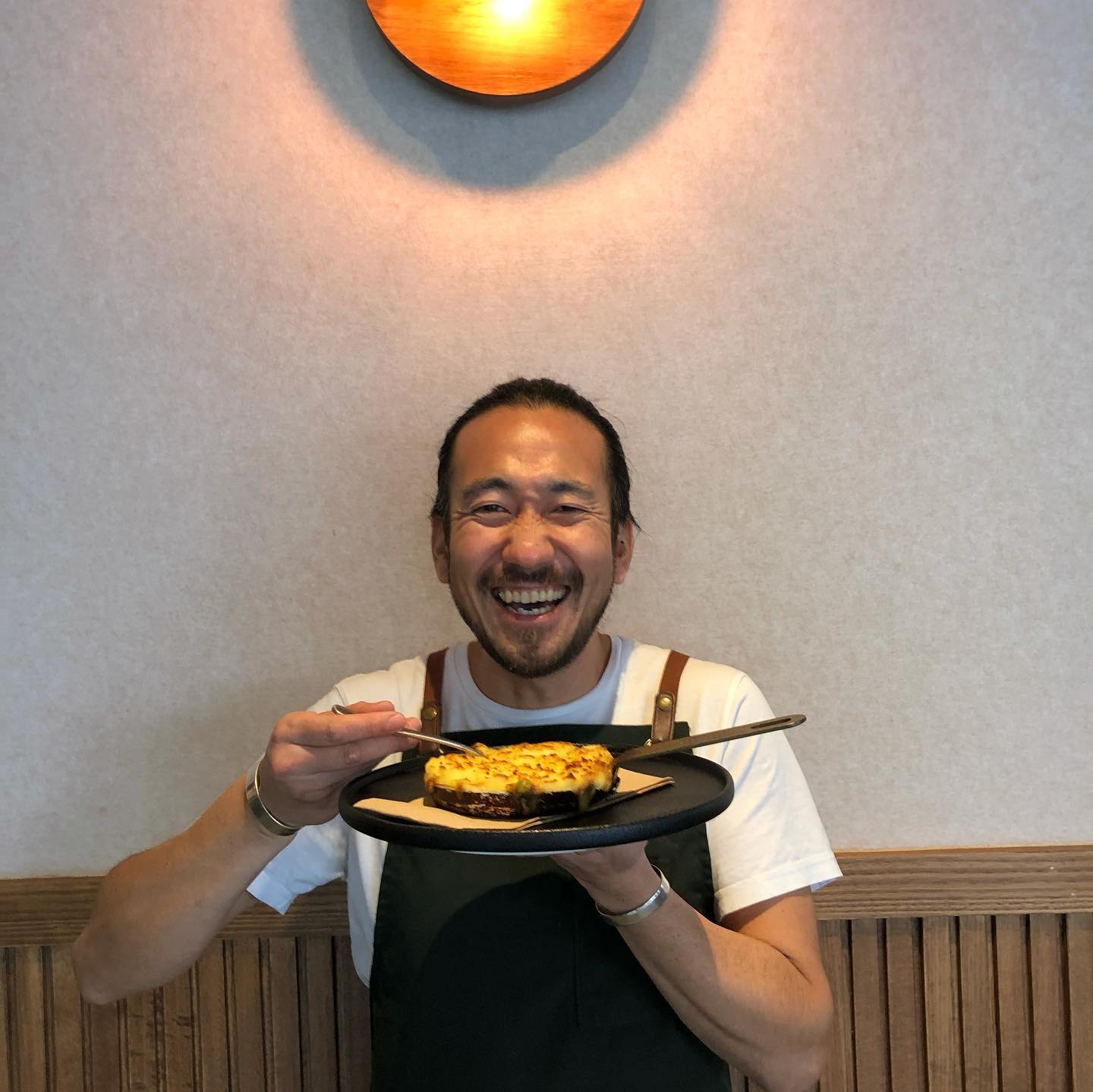 One of the team holding up a plate and smiling