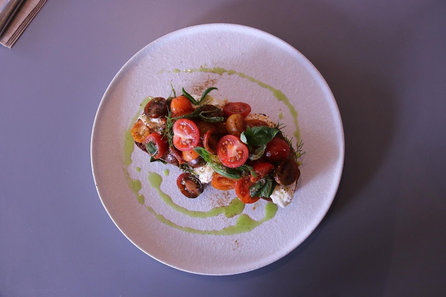 Tomatoes and stracciatella with herb oil, from above